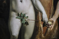 Ein Gemälde zeigt einen nackten Mann mit einem grünen Zweig vor dem Geschlecht