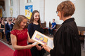 Während eines Gottesdienstes erhalten zwei Jugendliche ihr Konfirmationsurkunden von ihrer Pfarrerin.