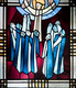 Das Foto zeigt den Ausschnitt aus einem bunten Kirchenfenster. Das Motiv zeigt Menschen, die nach oben blicken, wo Jesus in den Wolken verschwindet