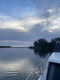 Ein Blick am Boot vorbei hinaus auf einen See während die Sonne aufgeht.