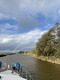 Ein Regenbogen spannt sich über einen Kanal bei Sonnenschein.