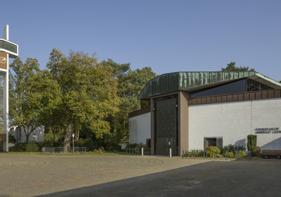 Weißes, moderner Kirchgebäude mit freistehendem Kreuz