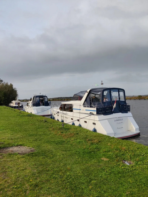Zwei Boote liegen an einem grünen Ufer.