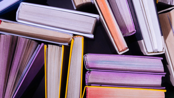 Auf dem Foto ist ein Bücherstapel zu sehen, Titel sind nicht zu erkennen