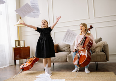 Nach dem Üben von Musikinstrumenten, schmeißt ein Kind freudig die Notenblätter in die Luft.