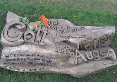 Das Foto zeigt das Mahnmal für Geflüchtete in der Bremer Gemeinde Arsten-Habenhausen. Es ist aus Bronze mit der Inschrift „Gott wird abwischen alle Tränen von ihren Augen - Im Gedenken an alle Menschen, die vor Krieg, Not und Verfolgung flohen und auf dem Weg zu uns ihr Leben verloren haben.“
