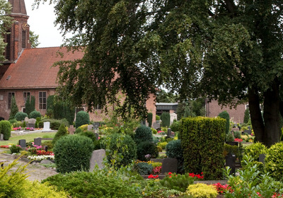 Die Kirche mit dem Friedhof und Bäumen.