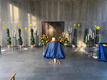 Innenansicht der Kapelle. Ein Altar, viele Kerzen und Blumengestecke befinden sich im Raum. Durch die Fenster scheint die Sonne.