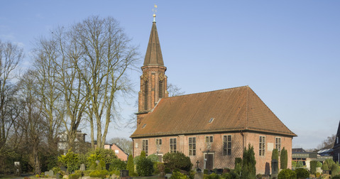 Kirchengebäude umgeben von einem Friedhof