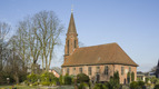 Kirchengebäude umgeben von einem Friedhof