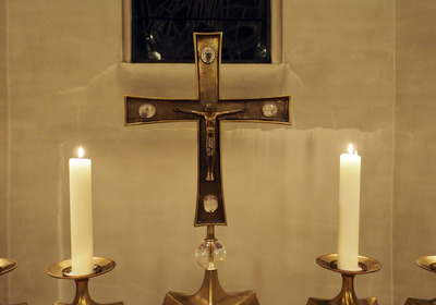 Altarkreuz zwischen brennenden Kerzen in der Alt-Hastedter Kirche