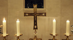 Brennende Kerzen neben dem Kreuz auf dem Altar der Alt-Hastedter Kirche