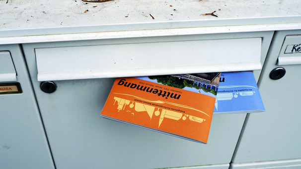 Ein Briefkasten mit zwei Ausgaben des Gemeindebriefes mittenmang