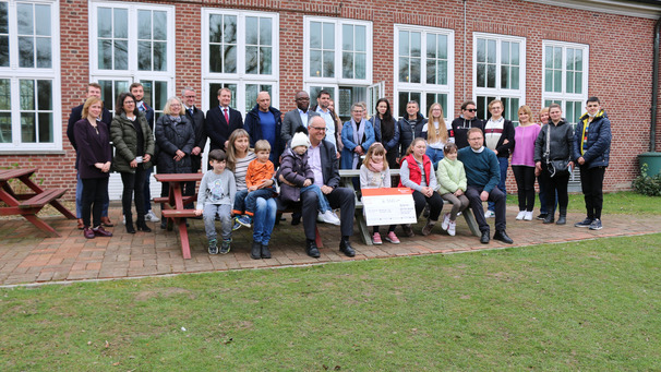 Gruppenbild aus der Bremer Gemeinde St. Markus. Mittig Bürgermeister Andreas Bovenschulte mit einem ukrainichen Kleinkind auf dem Schoß; rechts sitzend Pastor Andreas Hamburg.