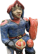 Eine farbenfrohe Figur eines Ritters in blauer und roter Kleidung, der lächelt. Er hält eine Krone in der linken Hand und hat ein Schild an seiner rechten Seite. Die Statue hat detailreiche Gesichtszüge und eine markante Kopfbedeckung.