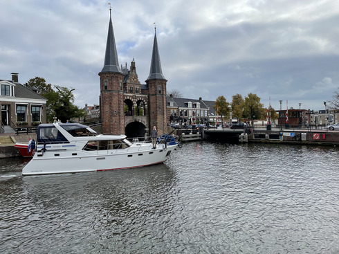 Ein Boot fährt an einem alten Wassertor vorbei.