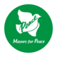 Rundes Logo in grün mit einer weißen Taube, die Frieden symbolisiert. Über der Taube steht das Wort "Peace" und darunter die Worte "Mayors for Peace". Das Design vermittelt eine Botschaft des Friedens und der Einheit.