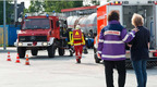 Das Foto zeigt einen Unglücksort. Im Hintergrund ein Feuerwehrfahrzeug, im Vordergrund ein Notfallseelsorge im Gespräch.