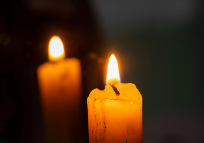 Das Bild zeigt zwei brennende Kerzen 