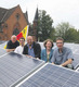 Das Foto zeigt Menschen aus der Bremer Friedensgemeinde auf dem Dach inmitten der Solarmodule