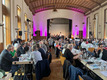 Das Foto zeigt das Plenum des Kirchentages an langen Tischen