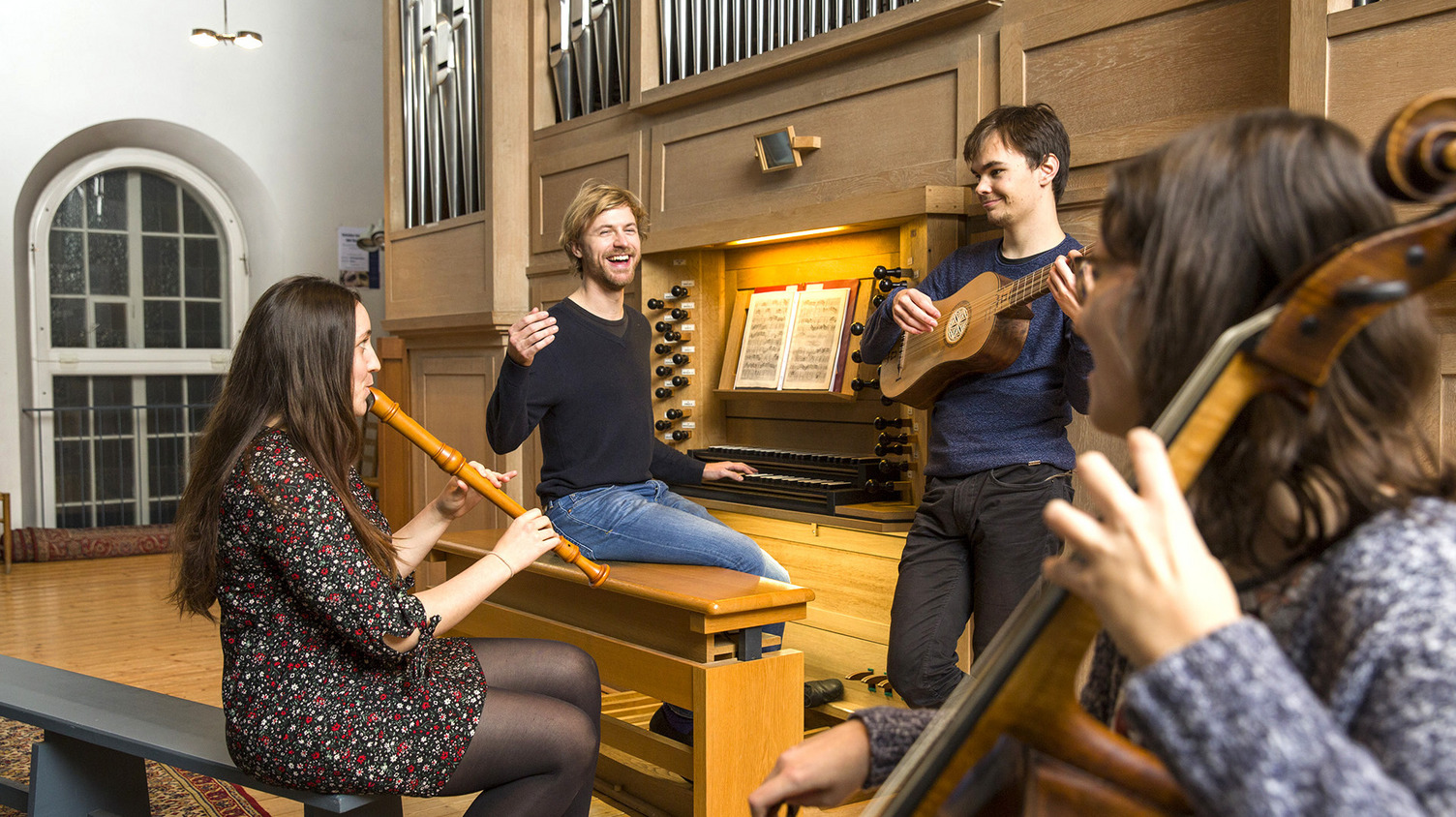 Kantor ﻿Jonathan Hiese an der Orgel mit mehreren Musiker*innen, die ihn auf ihren Instrumenten begleiten.