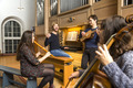 Kantor ﻿Jonathan Hiese an der Orgel mit mehreren Musiker*innen, die ihn auf ihren Instrumenten begleiten.