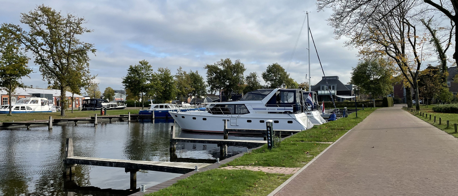 Zwei Boote liegen in einem Hafen nebeneinander. Der Hafen ist ansonsten leer und die Sonne scheint.