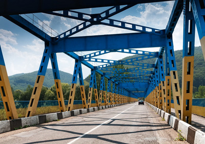 Das Foto zeigt eine blau-gelb gestrichene Brücke in der Ukraine