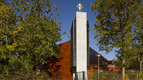 Kirchengebäude mit einem weißen Turm und goldenem Kreuz