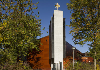 Kirchengebäude mit einem weißen Turm und goldenem Kreuz