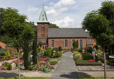 Kirchengebäude mit Friedhof und Bäumen