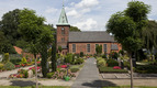 Kirchengebäude mit Friedhof und Bäumen