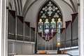 Das Foto zeigt die Orgel in der Bremer Propsteikirche St. Johann. Im Hintergrund sieht man ein buntes Glasfenster