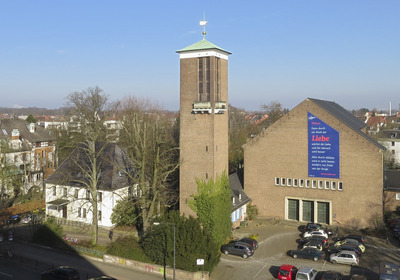 Kirchgebäude mit freistehendem Kirchturm im Stadtgebiet.