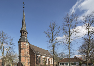 Kirche umgeben von Bäumen und Wohnhäusern