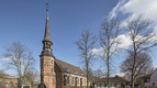 Kirche umgeben von Bäumen und Wohnhäusern