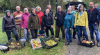 Das Foto zeigt eine Gruppe vonn Frauen und Männern, die Äpfel geerntet haben