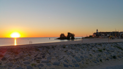 Ein Sonnenuntergang am Isselmeer, im Vordergrund der Strand von Urk