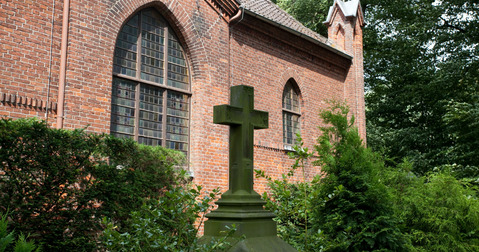 Ein steinernes Kreuz auf dem Friedhof.