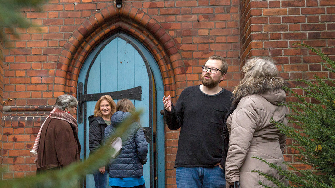 Jasper von Legat im Gespräch vor einer Kirche