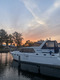 Ein Boot liegt im Hafen und dahinter geht die Sonne auf.