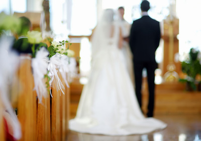 Ein Hochzeitspaar steht vor dem Altar in einer Kirche.