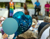 Zwei Luftballons beim "Main Tauffest 2022". Einer ist herzförmig und trägt die Aufschrift "Schön, dass du da bist".