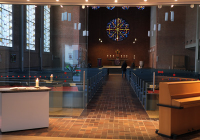 Blick durch die geöffnete Glastür der Kapelle (Vorraum der Kirche) zum Altar