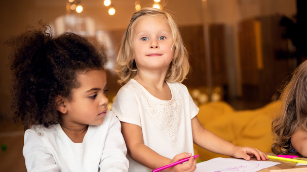 Im Kindergarten: Zwei Mädchen sitzen am Tisch und malen