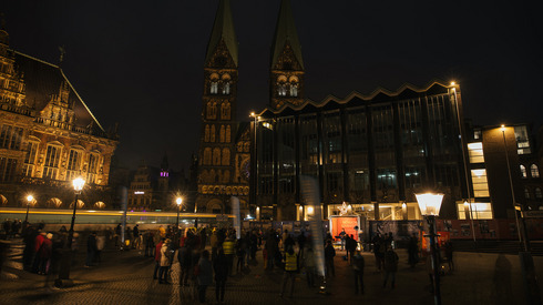 Die mobile Kirche auf dem Alten Marktplatz in Bremen bei Dunkelheit. Der ganze Marktplatz mit Dom ist zu sehen.