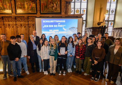 Das Foto zeigt Schülerinnen und Schüler, Preisträger des Schulwettbewerbs "Ich bin so frei!", in der oberen Rathaushalle in Bremen