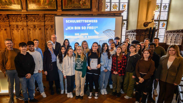 Das Foto zeigt Schülerinnen und Schüler, Preisträger des Schulwettbewerbs "Ich bin so frei!", in der oberen Rathaushalle in Bremen