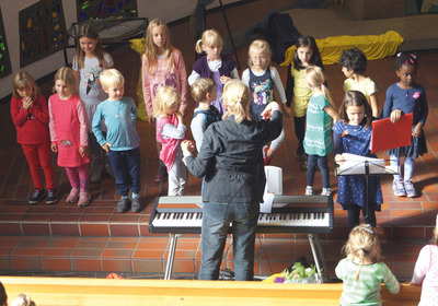 Eine Gruppe Kinder steht im Halbkreis und singt